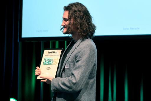 Dominic S. Müller avec le diplôme sur la scène du congrès du recyclage